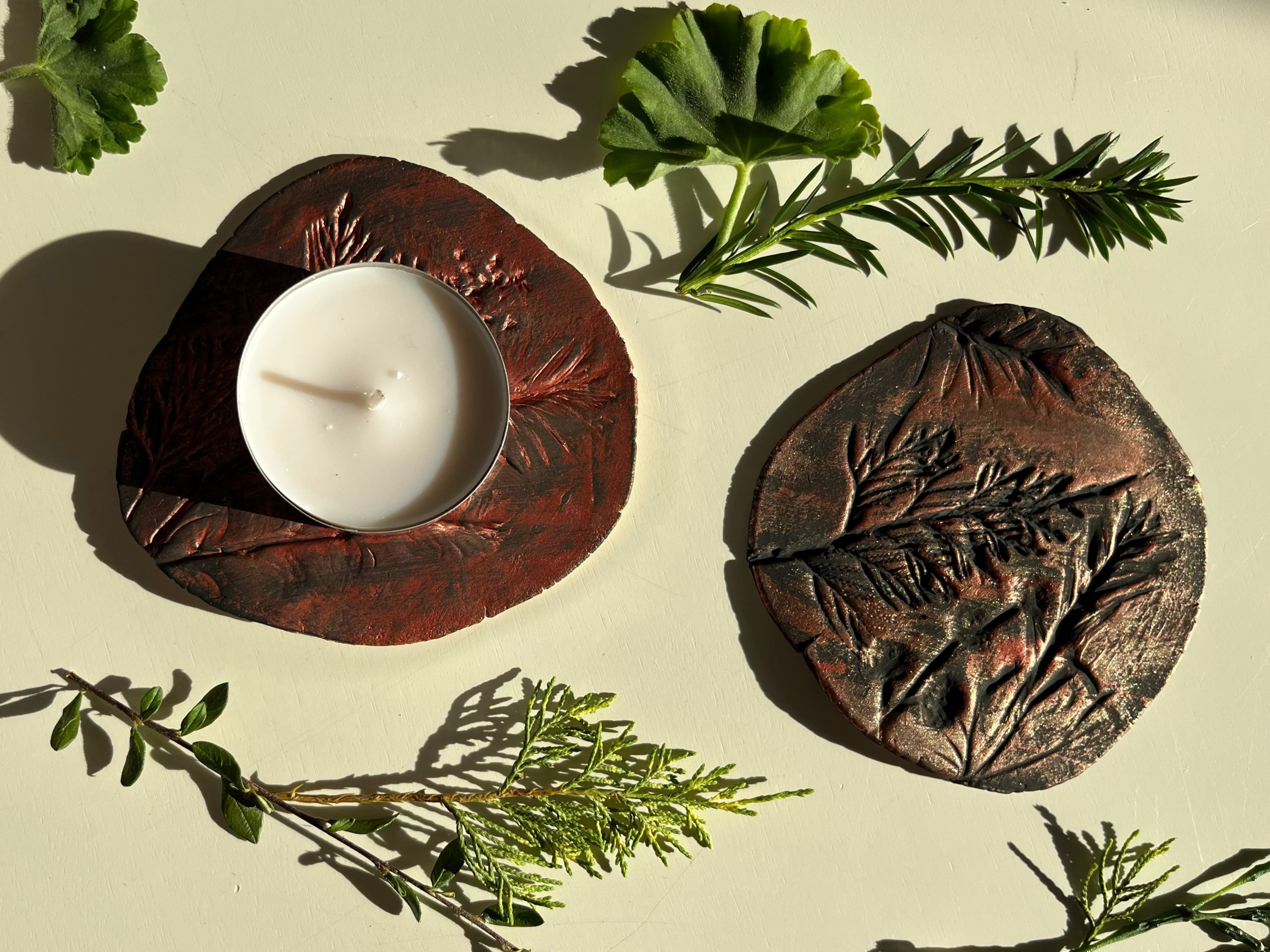 Ceramic candle holders with a candle and greenery